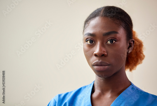 Portrait Of Serious Female Nurse Or Doctor Wearing Scrubs