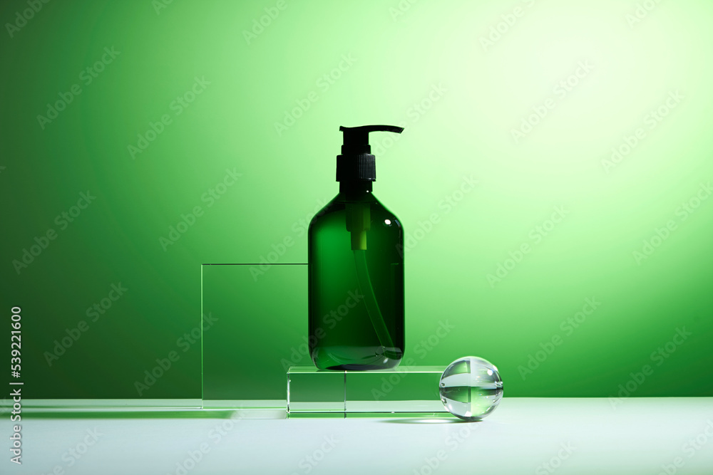 A product sample features a pump nozzle on a glass platform. Cosmetic product design with transparent geometric podiums on a green background. A product sample features a pump nozzle on a glass platform. Cosmetic product design with transparent geometric podiums on a green background.