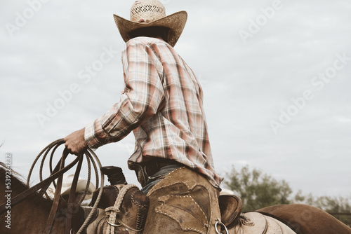 Cowboy in saddle horseback on ranch for western industry lifestyle concept. photo