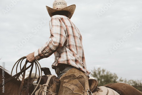 Cowboy in saddle horseback on ranch for western industry lifestyle concept.