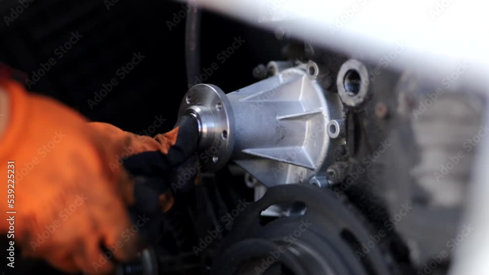 replacing the water pump of the car engine cooling system, a new aluminum car spare part pump. replacing the water pump of the car engine cooling system, a new aluminum car spare part pump.