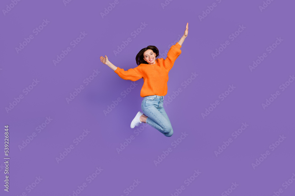 Full length photo of adorable young lady jumping high sportive wear trendy orange knitwear clothes isolated on violet color background