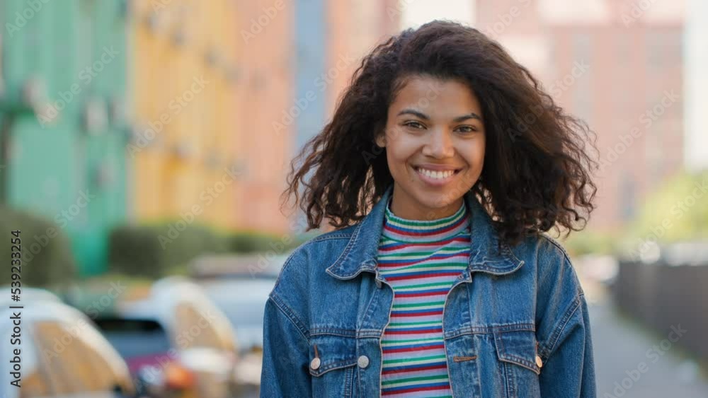 Portrait of African American girl standing on city street and smiling Portrait of African American girl standing on city street and smiling
