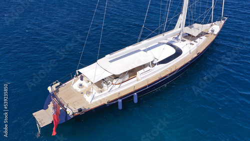 Aerial drone photo of beautiful sail boat anchored in deep blue open ocean sea