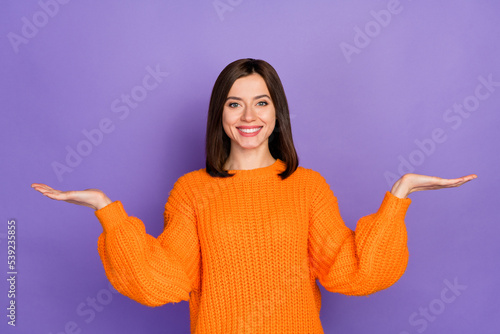 Photo portrait of nice young lady palms scales compare product dressed stylish knitted orange outfit isolated on purple color background photo