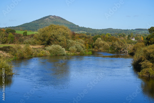 View of the Wrekin hill near Telford in Shropshire UK overlooking the River Severn taken from the bridge in Cressage with Autumn colours on the trees photo