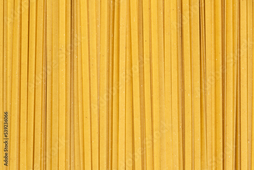 Durum fettuccine noodles background. Close up of raw spaghetti. Full frame of pasta