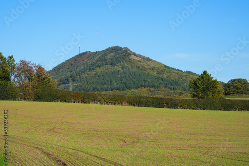 View of the Wrekin hill near Telford in Shropshire UK overlooking rural fields with Autumn colours on the trees photo