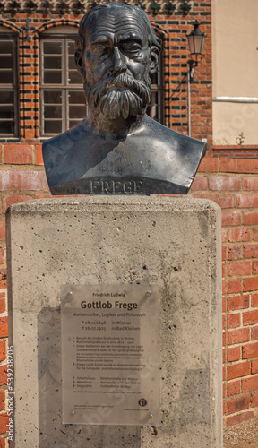 Germany, Wismar - July 13, 2022: St. Marienkirche. Closeup of Gottlob Frege bust statue on east side of grounds. Red bricks as backdrop. photo