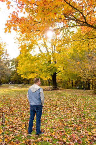Man Standing Alone Among Autumn Trees, Leaves, and Forest © Jenna Hidinger Photo
