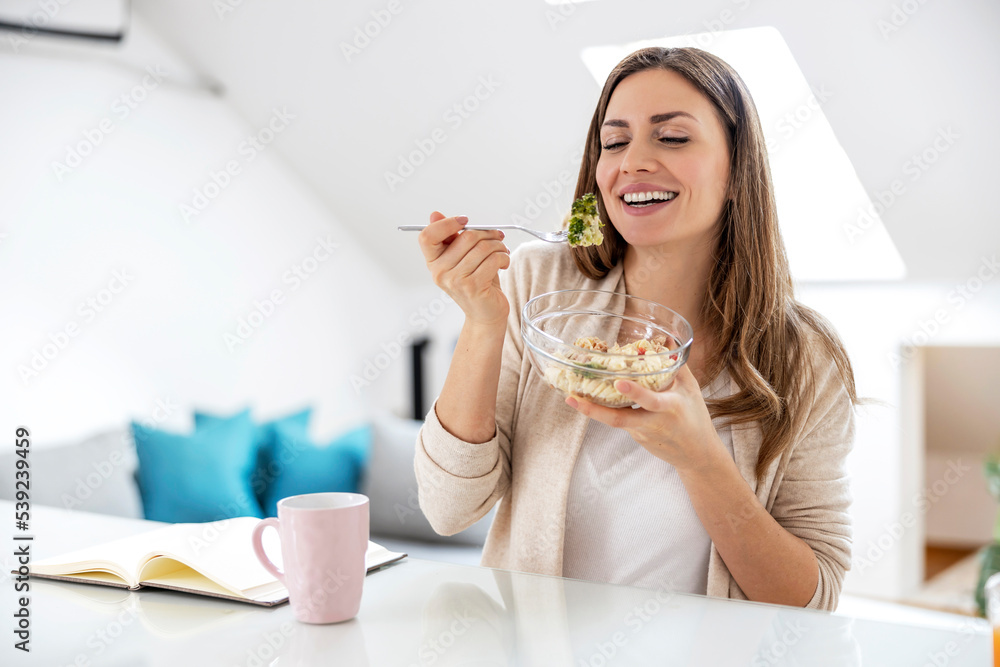 Woman eating salad at home