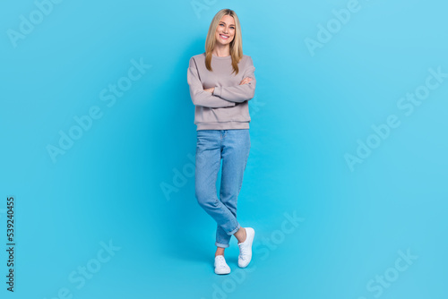 Full length photo of pretty confident girl dressed grey sweatshirt smiling standing arms crossed isolated blue color background