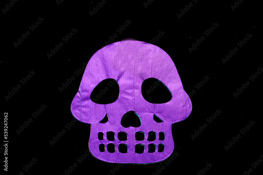 Obraz premium Colored papel picado for an offering for the Mexican tradition of the Day of the Dead and All Saints with skull shapes on a black background