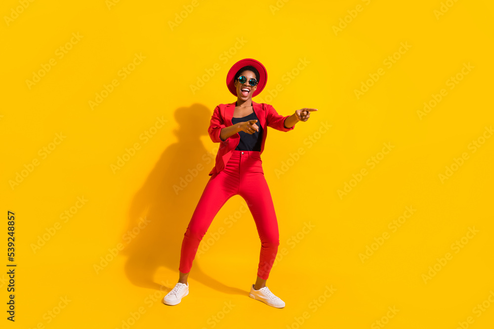 Photo of attractive funky short hair human wear formal outfit cap eyewear dancing pointing empty space isolated yellow color background
