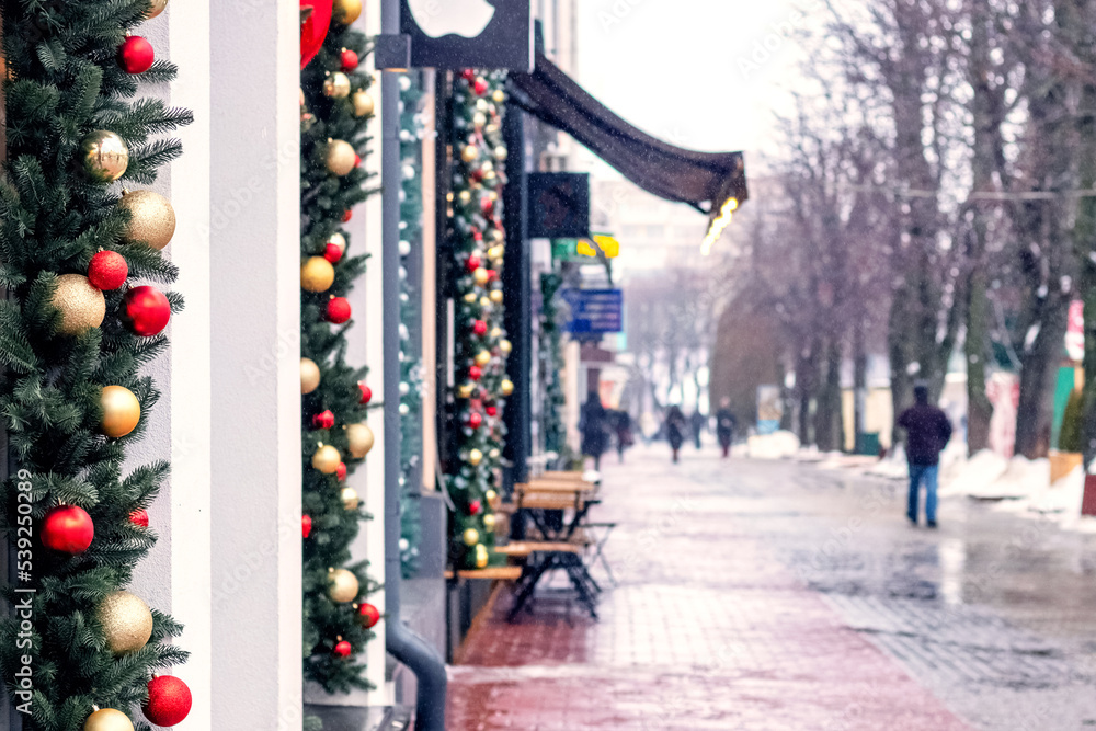 Obraz premium The city street is decorated with fir branches and toys on Christmas Eve