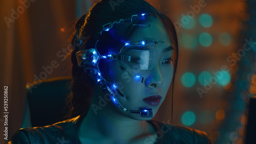 Wallpaper Mural A Cyberpunk girl works on the computer in the red neon lights. Asian girl with futuristic one-eyed glasses and microphone. Cyber and sci-fi backgrounds. Torontodigital.ca
