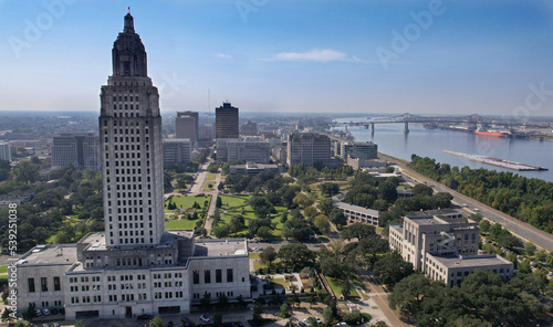 Baton Rouge State Capitol Louisiana city Mississippi River bridge levee tug boats mid angle up close afternoon