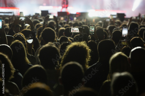 People with mobile phones at a concert. Hands with mobile phone. public at a concert takes photos with the mobile.