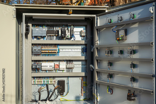 Electric control panel outside. Waste water equipment electrical automation cabinet. Open box with wires, contacts and terminal blocks close-up.