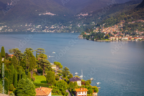 Obraz na płótnie Idyllic Lake Como coastline with village and sailboat at dramatic sunset, Italy w salonie