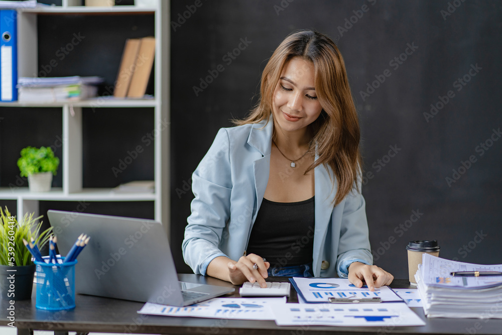 business woman working in office with laptop and working finance graph document Review and calculate financial costs annual balance sheet financial balance sheet business woman working in office with laptop and working finance graph document Review and calculate financial costs annual balance sheet financial balance sheet