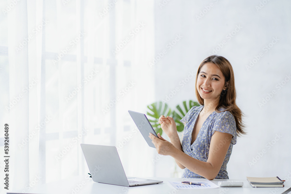 Independent Asian woman working from home Business woman using laptop sitting on a desk in home office, lifestyle concept, woman working online on the internet. Independent Asian woman working from home Business woman using laptop sitting on a desk in home office, lifestyle concept, woman working online on the internet.