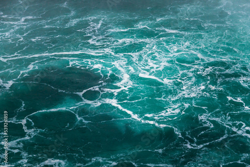Defocused water background - whirlpool waves, blue tint. Abstract background with liquid fluid texture. Niagara river 