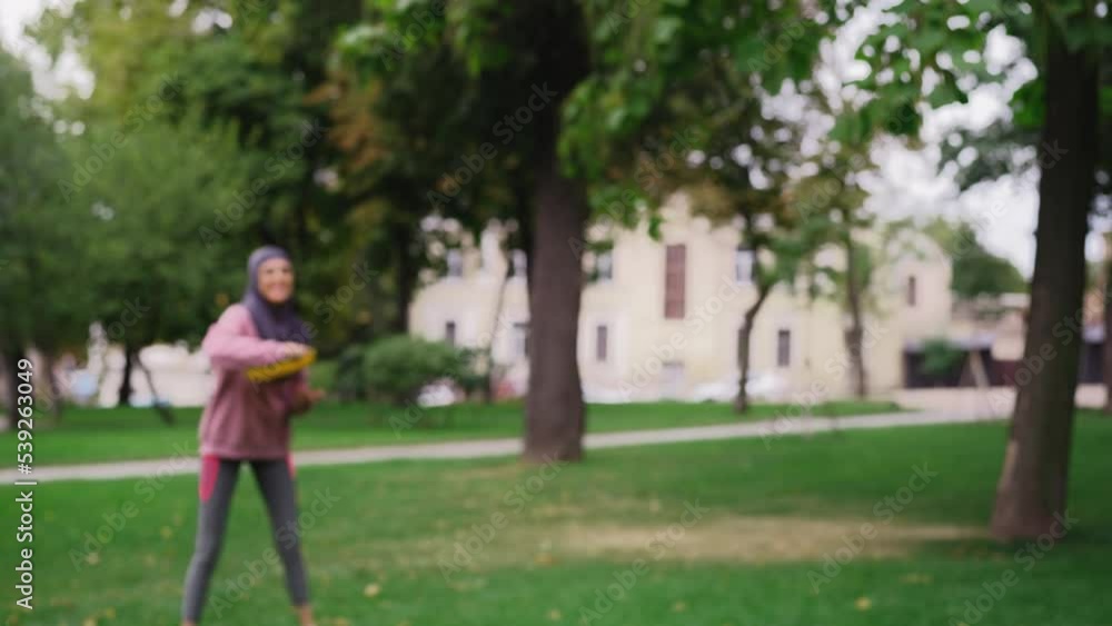 Two muslim women throwing and catching the flying disc, training partners Two muslim women throwing and catching the flying disc, training partners