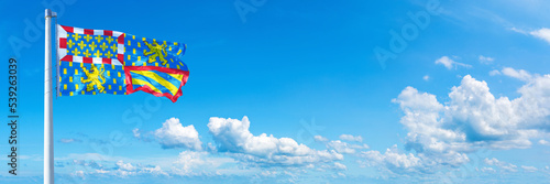 Bourgogne-Franche-Comté, France - flag waving on a blue sky in beautiful clouds - Horizontal banner