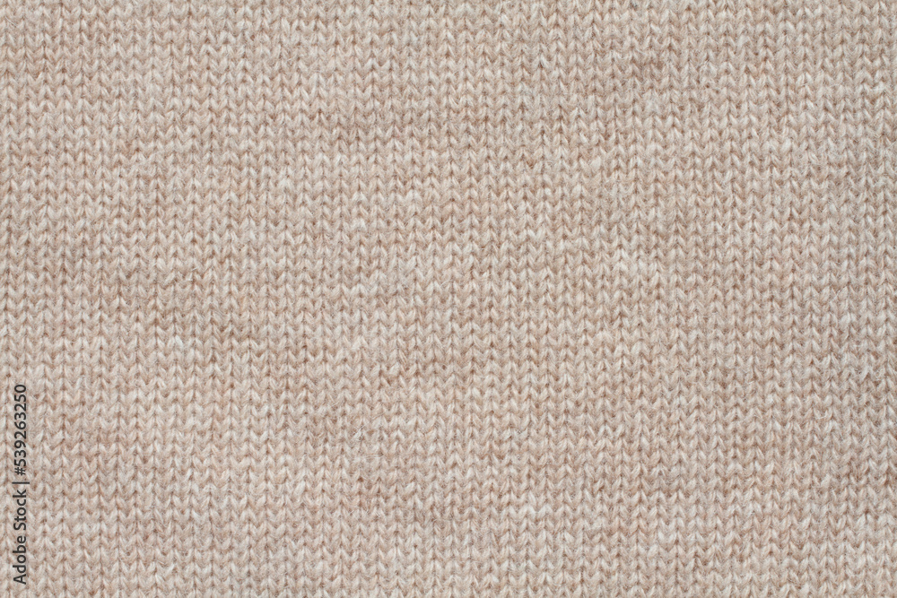 Light beige woolen knitted fabric texture. Macro. Light beige woolen knitted fabric texture. Macro.