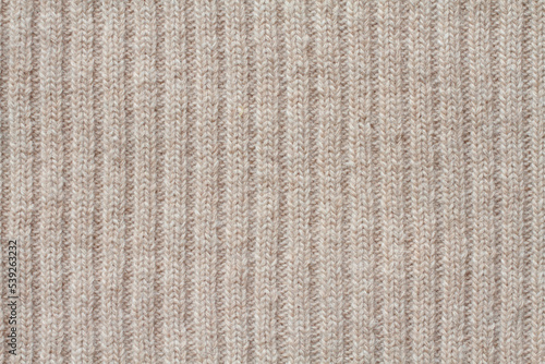 Light beige woolen knitted fabric texture. Macro.