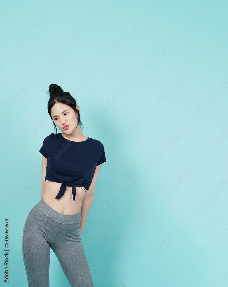 Fitness sportswear woman smile and pose body exercise at camera isolated on blue green background. Perfect body sporty woman relaxing after training. Fit and firm people. Sport Health and wellness. Fitness sportswear woman smile and pose body exercise at camera isolated on blue green background. Perfect body sporty woman relaxing after training. Fit and firm people. Sport Health and wellness.