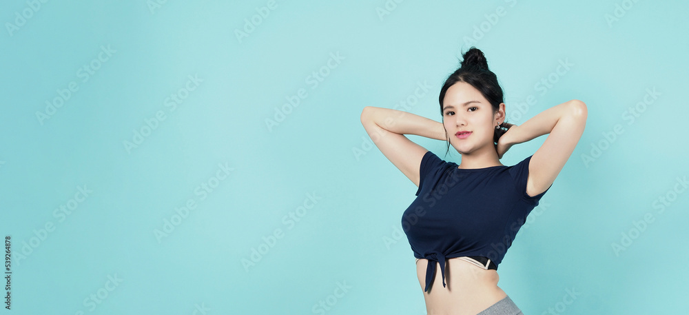 Fitness sportswear woman smile and pose body exercise at camera isolated on blue green background. Perfect body sporty woman relaxing after training. Fit and firm people. Sport Health and wellness.