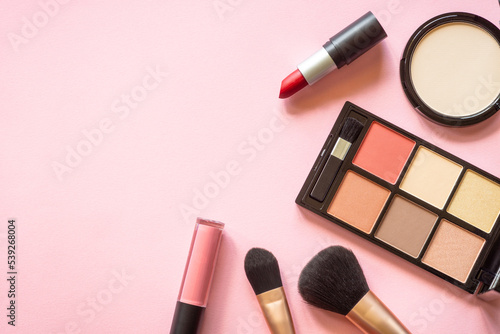 Makeup professional cosmetics on pink background. Flat lay with copy space.