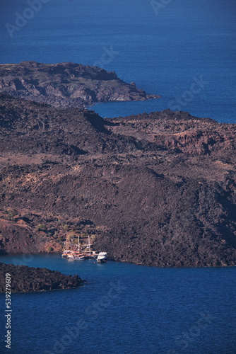 Tourist Yachts Moored in a Bay in Nea Kameni Greek Volcano island in the Aegean Sea, within the flooded Santorini caldera in Greece