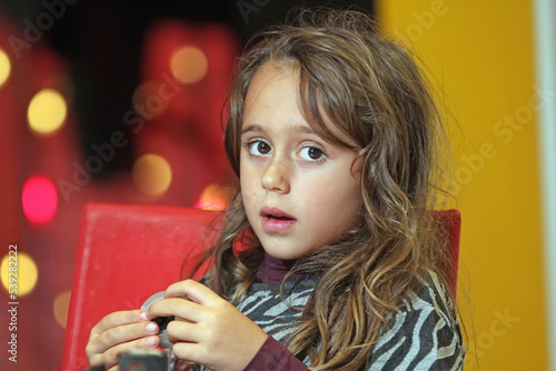 Young girl 6-7 years old looks straight ahead