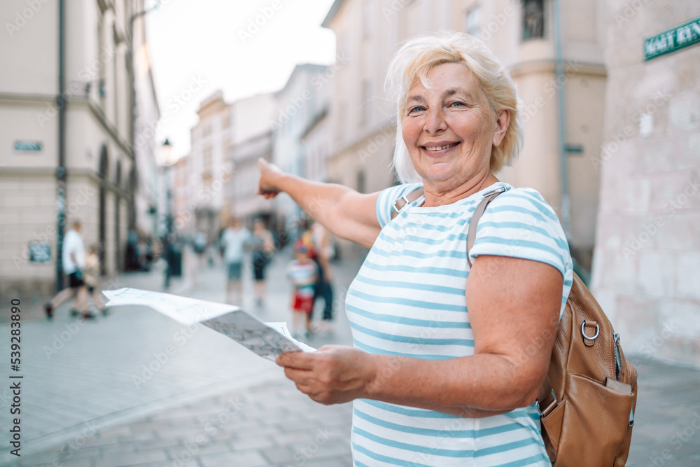 Mature traveller woman walking on old town holding tourist map. Travel and active lifestyle concept. Mature traveller woman walking on old town holding tourist map. Travel and active lifestyle concept.