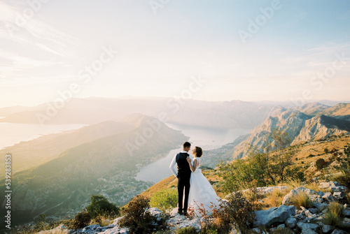 Print op canvas Groom hugs bride on a mountain above the Bay of Kotor