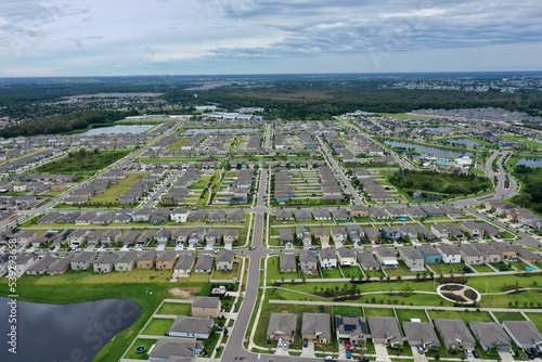 Aerial view of a suburb in Austin, Texas with trees and a cloudy sky in the background.