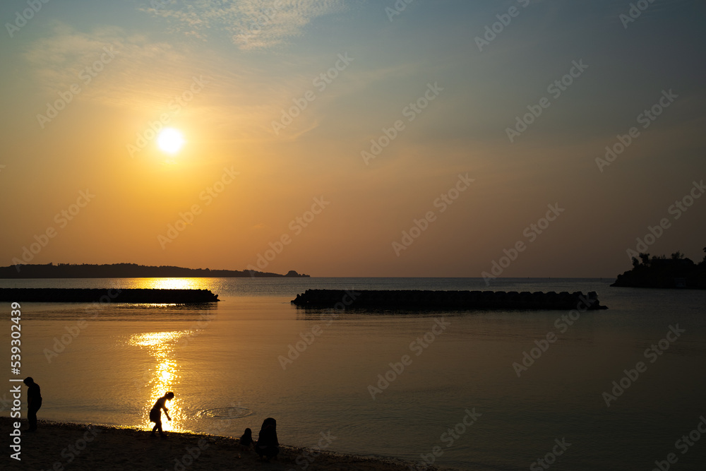 沖縄の夕陽と海、人のシルエット