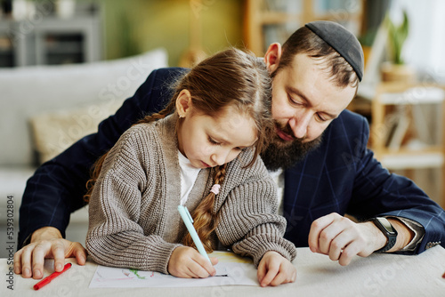 Obraz na plátně Portrait of caring jewish father drawing pictures with daughter at home