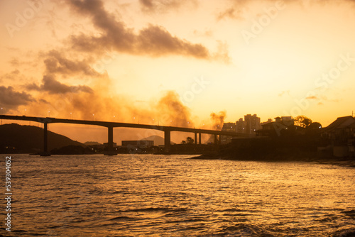 terceira ponte de Vitoria ao atardecer com o mar e o ceu amarelos 