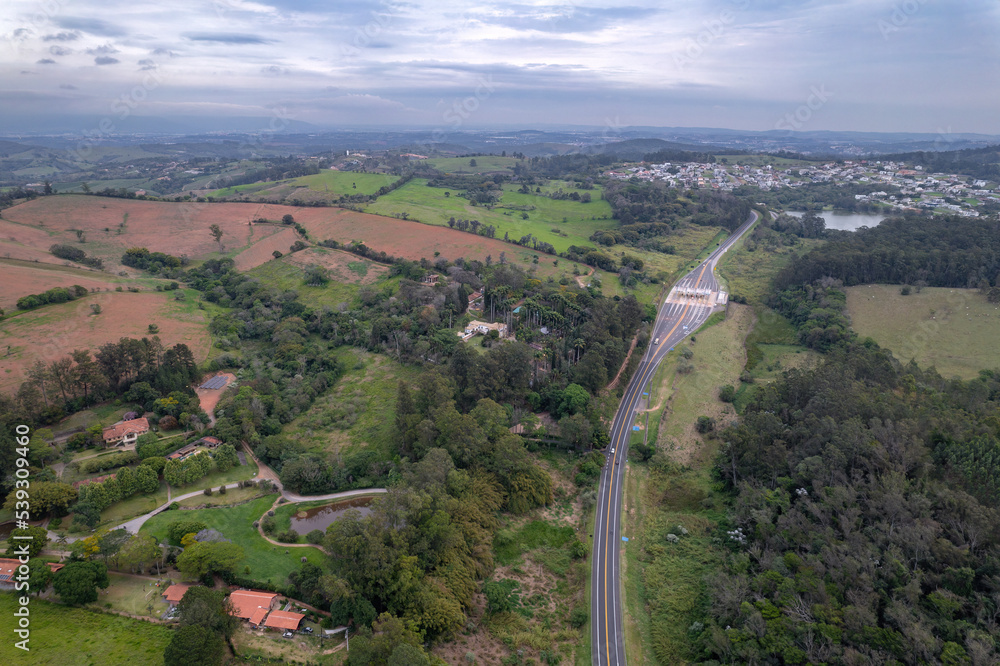 Aerial image of the Romildo Prado highway and its toll booths. Road with vegetation around it and car traffic.