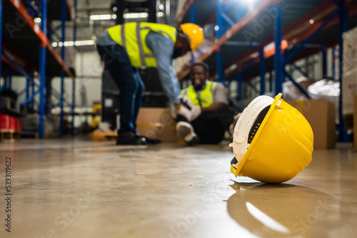 Factory Accident, Industrial accident. Warehouse staff having accident in the factory, industrial worker injured during working having pain on leg, worker helping and giving the injured first aid