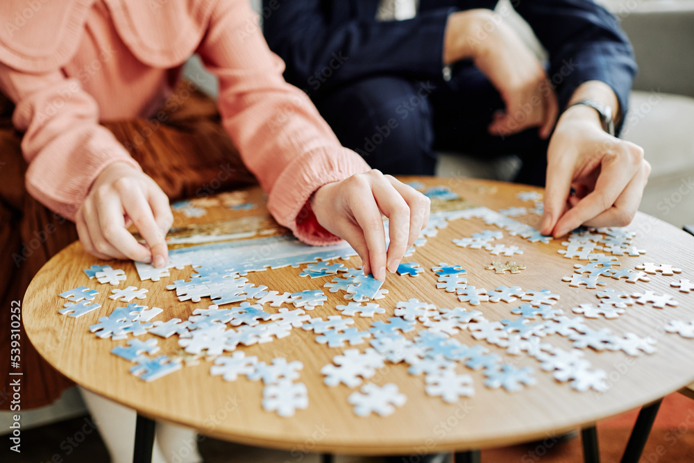 Close up of father and daughter playing puzzle game together at home, copy space Close up of father and daughter playing puzzle game together at home, copy space