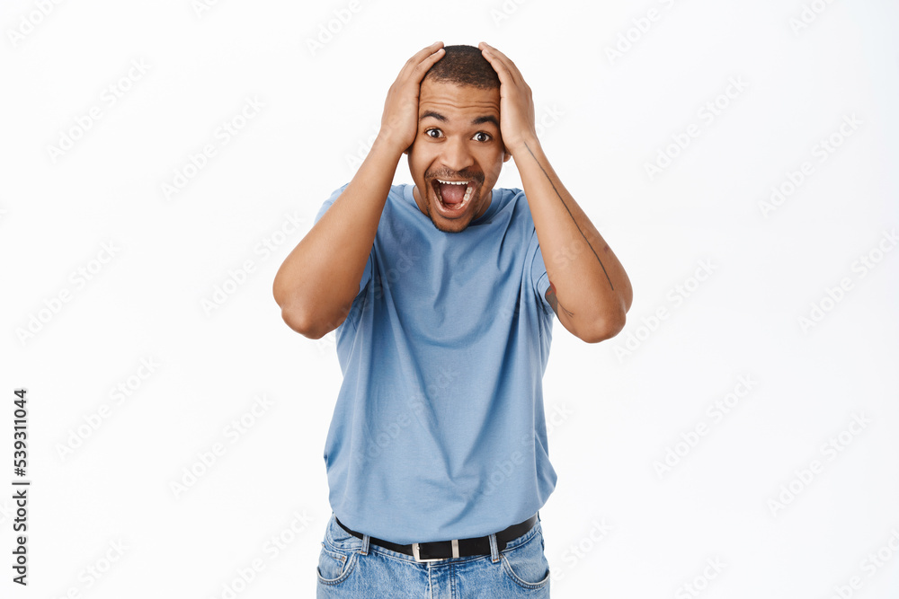 Portrait of man looking surprsied and happy, joyful disbelief, standing amazed against white background Portrait of man looking surprsied and happy, joyful disbelief, standing amazed against white background