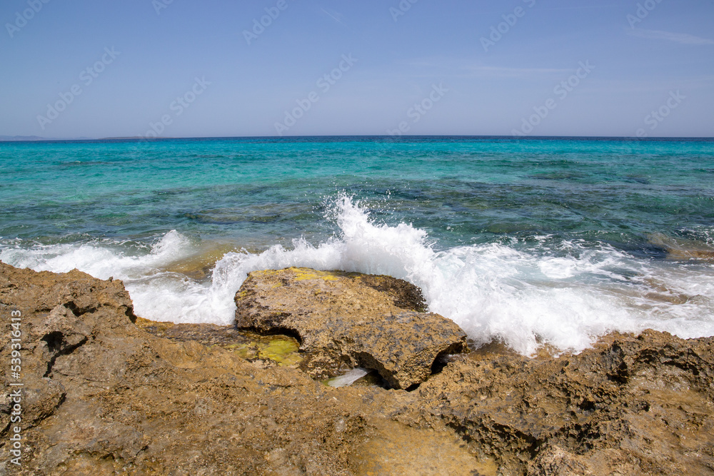 Rocky beach with a turquoise blue sea and waves in spain Rocky beach with a turquoise blue sea and waves in spain