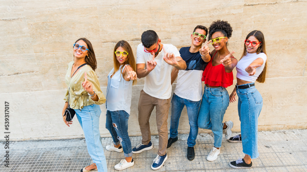 Happy young people holding fake eyeglasses having fun – group of friends at a party having fun fake glasses - Photo and carnival funny accessories concept
