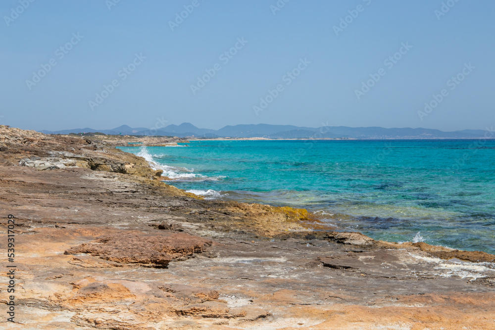 Rocky beach with a turquoise blue sea and waves in spain Rocky beach with a turquoise blue sea and waves in spain