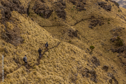 SIMIEN MOUNTAINS, ETHIOPIA - MARCH 16, 2019: Tourists hiking in Simien mountains, Ethiopia